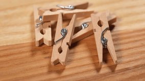 Wood clothespins on wooden background.