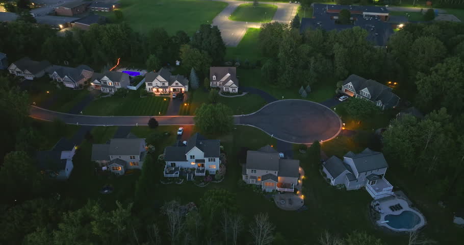 Cul de sac street dead end at night and private residential houses in rural suburban sprawl area in Rochester, New York. Upscale suburban homes with large backyards