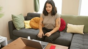Hispanic woman consults during telemedicine appointment from her living room, showing concern.