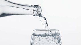 Water being poured into a glass from bottle creating bubbles isolated on white background. Essential role water. Concept of refreshment, aesthetics of product, health, wellness, hydration - Powered by Shutterstock - Get 15% off with code: PIKWIZARD15