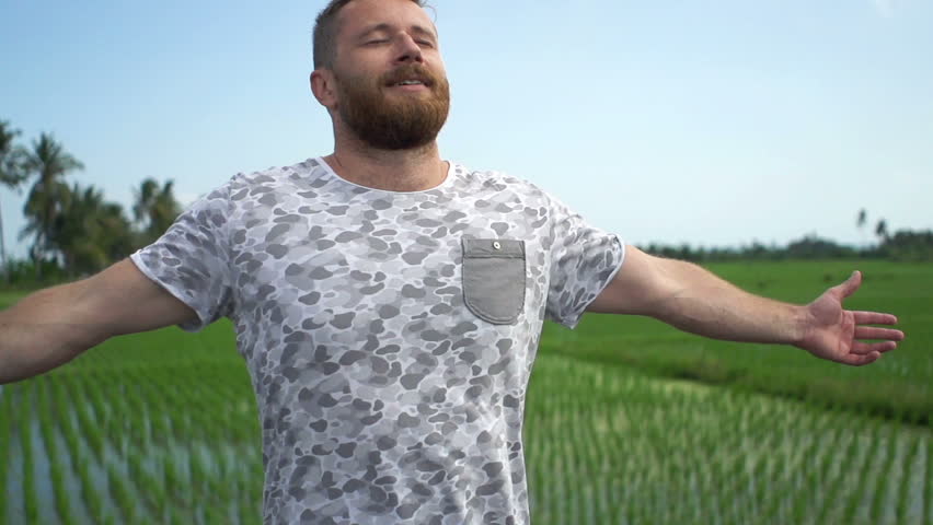 Happy man with wide open arms enjoying day in country
