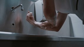 Surgeon doctor washes his hands before surgery in a special modern room with a stainless medical sink in the clinic preparing for surgery - Powered by Shutterstock - Get 15% off with code: PIKWIZARD15