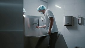 Surgeon doctor washes his hands before surgery in a special modern room with a stainless medical sink in the clinic preparing for surgery - Powered by Shutterstock - Get 15% off with code: PIKWIZARD15