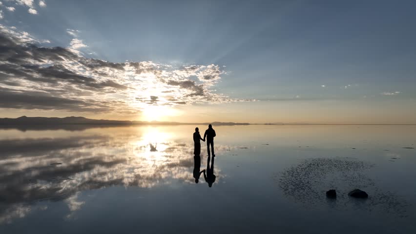 Salar de Uyuni in Bolivia during sunset. Aerial image taken with a drone. Uyuni Salt Flats. Altiplano, Bolivia. Rainy Season. Tunupa Volcano. Clouds Reflection on Water in Lake Surface