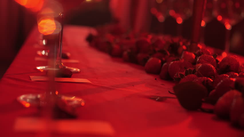 empty wine glasses lined up in a red light on a decorative table. Royalty-Free Stock Footage #3478746111