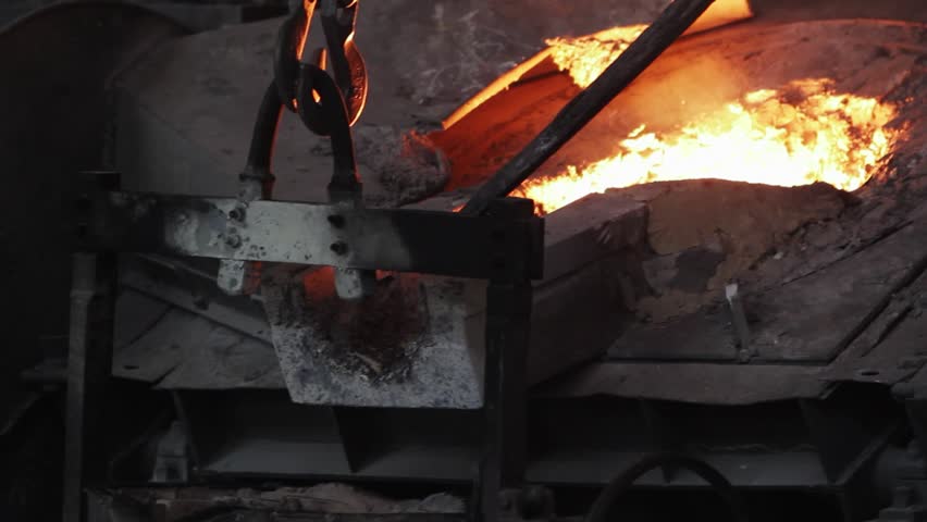 Industrial foundry steel casting, molten metal poured from ladle into mold. Heavy industry manufacturing process, extreme heat, sparks fly. Metallurgy, engineering, equipment operate in plant.