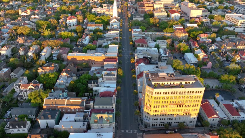 Sunrise over Downtown Charleston, SC, with historic district aerial view, highlighting vibrant rooftops and streets.
