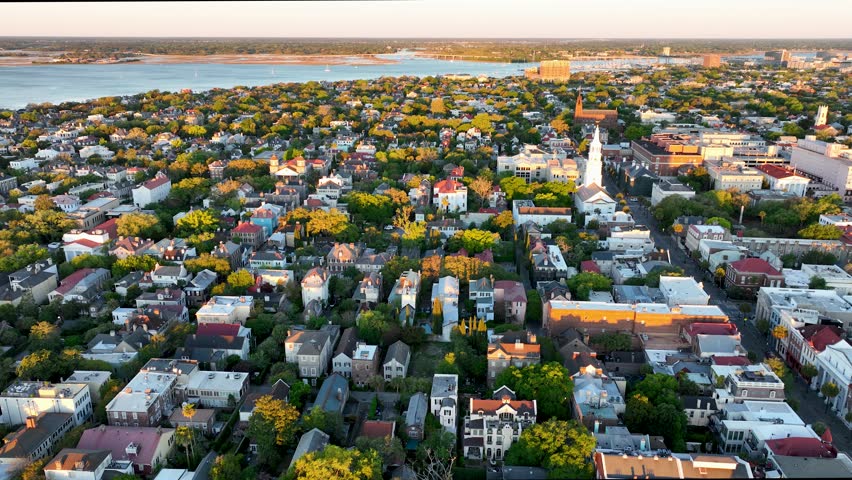 Sunrise over Downtown Charleston, SC, with historic district aerial view, highlighting vibrant rooftops and streets.