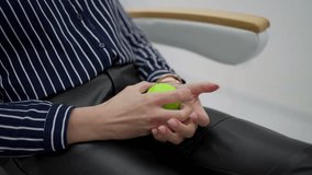 Hand exercises with anti-stress ball in medical center. Woman squeezes green anti-stress ball. Concept of rehabilitation and recovery - Powered by Shutterstock - Get 15% off with code: PIKWIZARD15