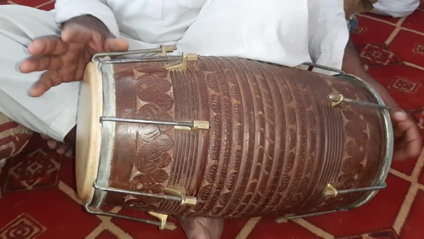 A Man Playing Dholak. Closeup shot of hands of a Man playing Dholak. Traditional world. Folk instrument. Wood Instrument. Pakistani man playing Dholak in the house. Beautiful 4K Footage.