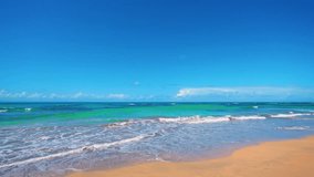 Hawaiian beach with golden sand and clouds in the blue sky above the ocean. Tropical landscape of sea islands. Sandy coast of a wild beach. Sea voyage during the summer holidays.