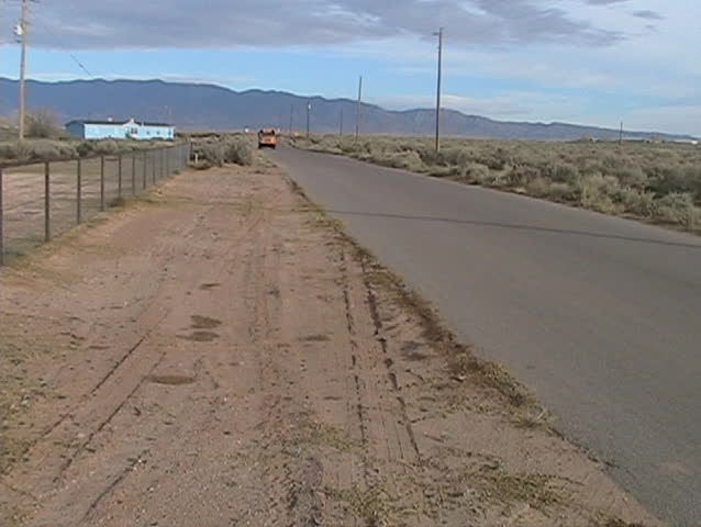 Handheld shot of a school bus driving by in a rural area.