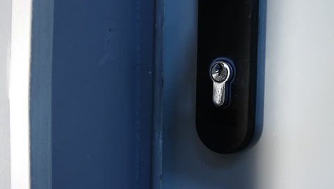  locksmith hands using pick tools to open locked door