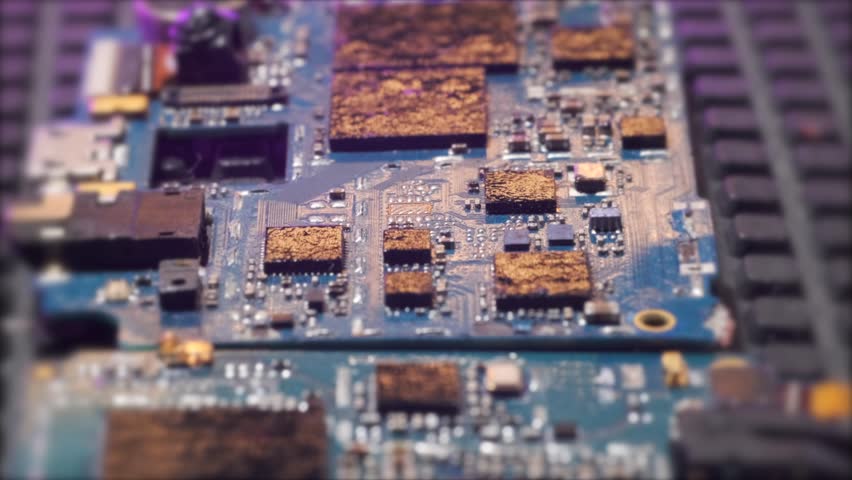 Close up on old melted,  electronic circuit board, set on fire motherboards, tracking shot, blurred background.  Microcircuits surface.