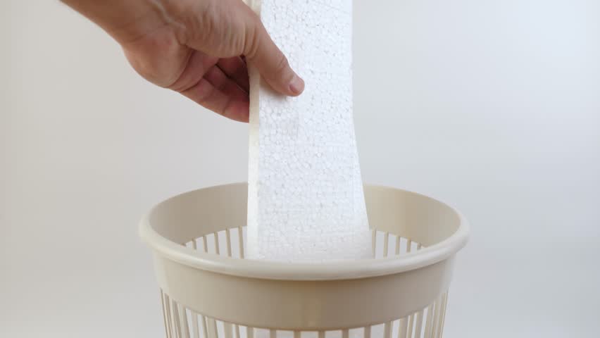 Pieces of Styrofoam are thrown into the trash can. Disposal of household waste.