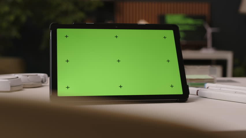No people closeup of digital tablet with green template screen on display on table in modern office