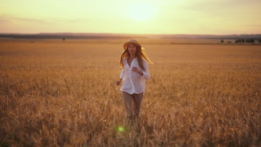Romantic carefree happy woman running on yellow wheat field with spreading flying arms enjoying freedom calmness on rural nature during vacations holidays. Rest, relax in country, village outdoors. Royalty-Free Stock Footage #3479088969