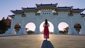 Slow motion video.Chiang Kai  Shek Memorial Arch with morning sunlight and Asian women in Taipei, Taiwan. The meaning of the Chinese text on the archway is 