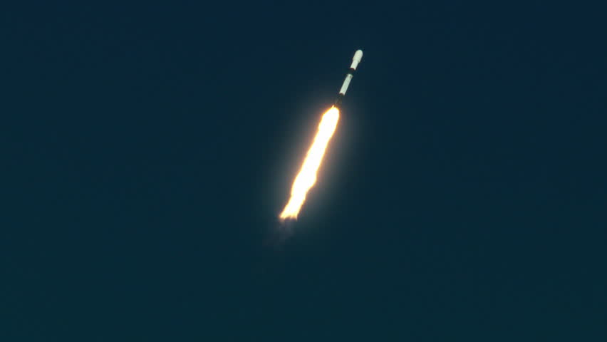 Rocket flying into space from Florida launch pad with flames, fire, and smoke exhaust as it rises into the sky. 4K slow-motion with audio.