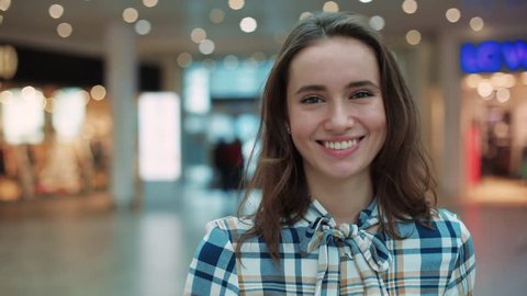 Attractive young woman look ar camera smiling feel happy in mall close up shopaholic clothing fashion person girl shopping money lifestyle store portrait weekend shop slow motion