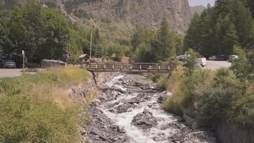 Empty Walking Bridge over Alpine Torrent - Wide Angle