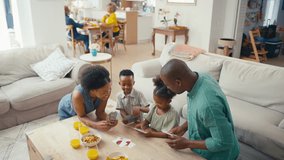 Family indoors at home sitting around table playing game of cards with grandparents in background - shot in slow motion - Powered by Shutterstock - Get 15% off with code: PIKWIZARD15
