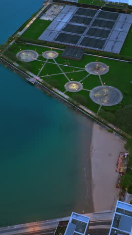 Lovely green areas and amusement park at the waterfront of Lake Michigan. Fantastic turquoise water of lake from aerial view. Vertical video