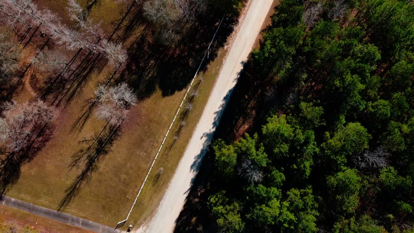 Aerial top down of trees and four way stop and a gravel trail in rural Appling Georgia USA