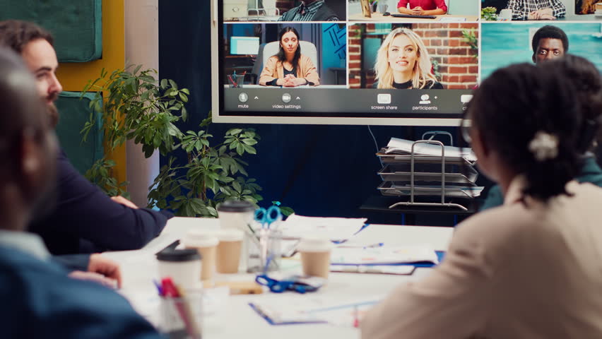 Business associates meeting with stakeholders on a videocall connection, sharing insight and updates on a new development project. Executive board members discussing about firm growth. Camera A.
