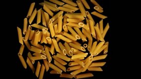 Super slow motion of falling raw Italian penne pasta on black background - Powered by Shutterstock - Get 15% off with code: PIKWIZARD15