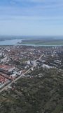 Aerial view of small city. River and agriculture fields in the background. Vertical video