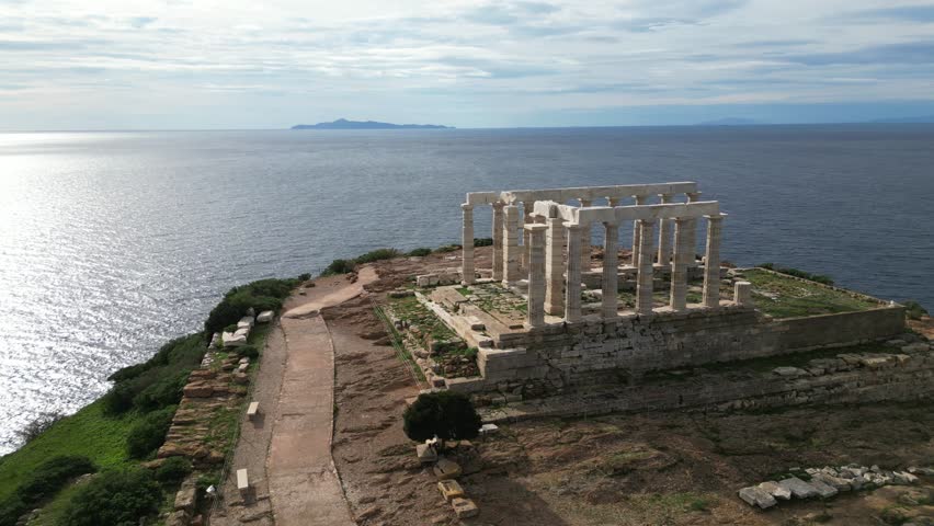 Temple of Poseidon is one of the most famous monuments in Greece , perched on a rocky promontory overlooking the Egean Mediterranean  sea , Cape Sounion - drone aerial view of Unesco Heritage world 