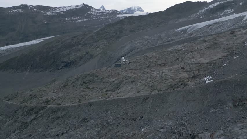 Approaching a modern mountain hut near rocks and snowy glaciers, near Monte Rosa, Switzerland. Aerial drone straight	 Royalty-Free Stock Footage #3479675155