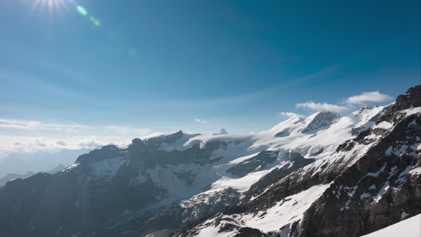 Thin clouds flying over alpine mountains, in time lapse, during sunset with bright blue skies, in Breithorn, Monte Rosa, Italy	 Royalty-Free Stock Footage #3479678385