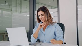 Smiling busy mature middle aged professional business woman manager executive or entrepreneur looking at laptop computer in office working writing notes watching webinar sitting at desk. - Powered by Shutterstock - Get 15% off with code: PIKWIZARD15
