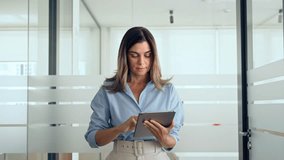 Smiling busy middle aged professional business woman manager, 45 years old female executive or mature entrepreneur holding tab digital tablet walking in office at work, looking at pad. - Powered by Shutterstock - Get 15% off with code: PIKWIZARD15