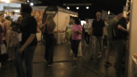 An out of focus video of people walking around the exhibition. 