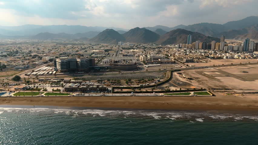 Aerial view of the coast. The city against the backdrop of mountains, view from the sea.