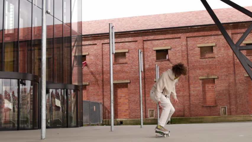 Z generation male doing an ollie with skateboard outdoors.