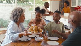 Grandparents with grandchildren indoors at home decorating cupcakes with icing and sprinkles together with parents in background - shot in slow motion - Powered by Shutterstock - Get 15% off with code: PIKWIZARD15