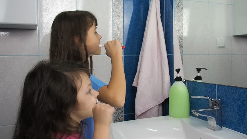 Children brush their teeth with a toothbrush. Two sisters in the bathroom with toothbrushes. | Shutterstock HD Video #34798879