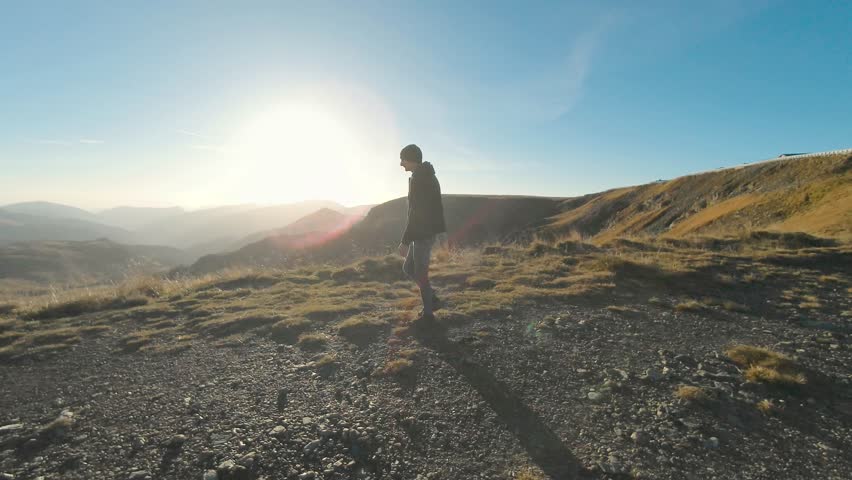 Male tourist walking on mountain path to the cliff