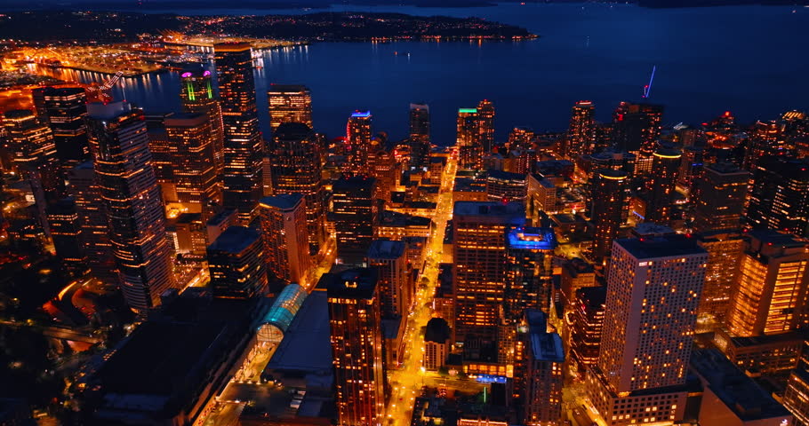 Spectacular scenery of modern Seattle, Washington, the USA. Gorgeous skyscrapers sparkling with lights at night in the downtown of metropolis. Lake Washington at backdrop. Top view.