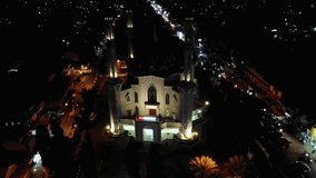 Footage of Drone fly away from a mosque at the city in Indonesia during the night