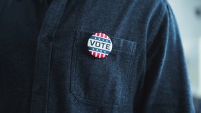 Anonymous African American man puts on badge with USA flag logo and inscription I Voted. US citizen at polling station during elections. National Election Day in United States of America. Close up. - Powered by Shutterstock - Get 15% off with code: PIKWIZARD15