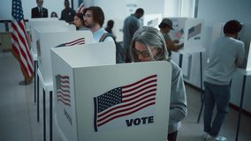 Elderly woman votes in booth in polling station office. National Election Day in the United States. Political races of US presidential candidates. Civic duty and patriotism. Slow motion. Dolly shot. - Powered by Shutterstock - Get 15% off with code: PIKWIZARD15