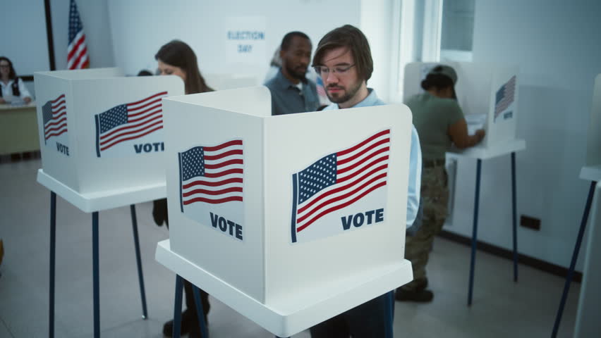 African American man comes to vote in booth in polling station office. National Elections Day in the United States. Political races of US presidential candidates. Civic duty. Slow motion. Dolly shot.