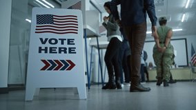 Vote here sign on the floor. Diverse American citizens vote in booths in polling station office. National Election Day in the United States. Political races of US presidential candidates. Civic duty. - Powered by Shutterstock - Get 15% off with code: PIKWIZARD15