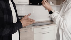 Young man and woman emotionally swearing and gesticulating their hands on the kitchen at home close up. Problems in the relationship of a couple - Powered by Shutterstock - Get 15% off with code: PIKWIZARD15