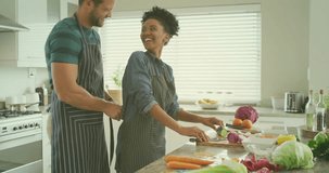 Animation of super foods text over diverse couple preparing healthy meal in kitchen. Organic food, healthy eating and cooking concept digitally generated video.